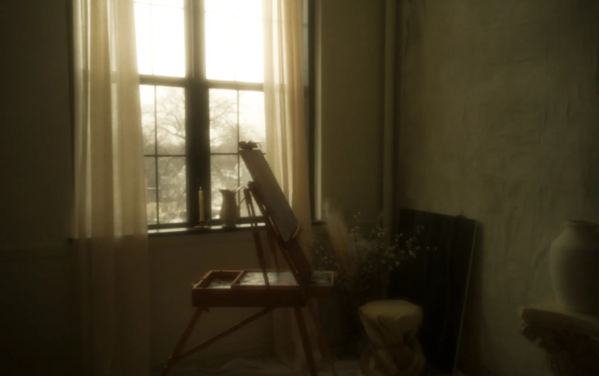 A field easel and palette by a curtained studio window in soft morning light.